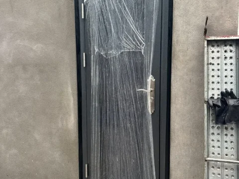 Pintu aluminium pada dinding rumah